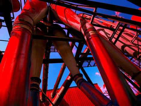 Industrial Pipes And Building In Red With Blue Sky