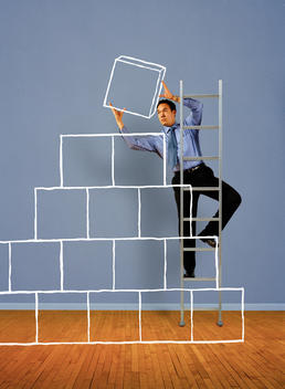 Man on ladder stacking illustrated boxes
