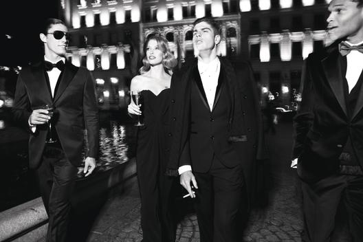 Gorgeous black tie fashion, at night, 1 girl, 3 boys, champagne and diamonds while they party on the streets of Fifth Avenue in New York City.