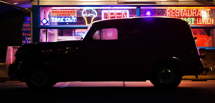 Side view silhouette of Vintage Van outside diner at night