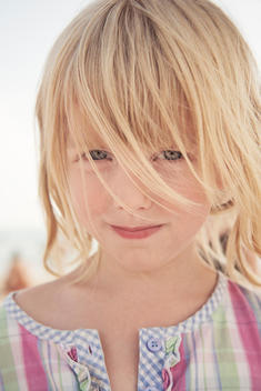 Young blonde girl staring in to camera.