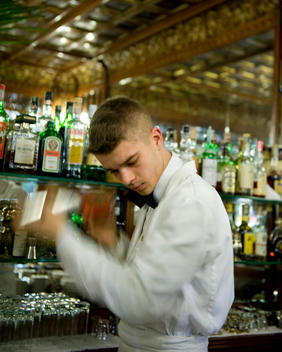 Cafe Mulassanoportici in Piazza Castello, opened in 1907, a Bar man mixes a cocktail, using a cocktail shaker