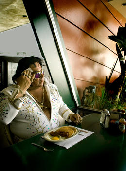 Portrait Of Overweight Elvis Impersonator Eating Alone In Diner