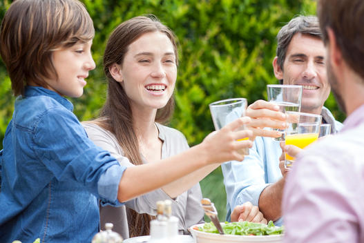 Family clinking glasses at outdoor gathering
