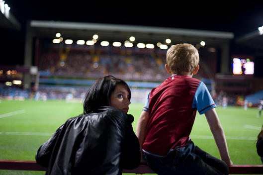 Mum, Football Supporter With Son Watching English Premiership Match