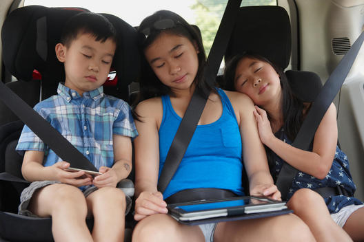 Chinese children napping in backseat of car