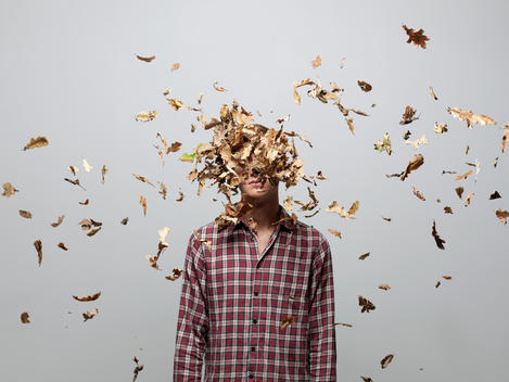 Young man with face obscured by leaves