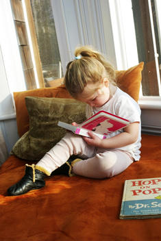 Child reads on window bench