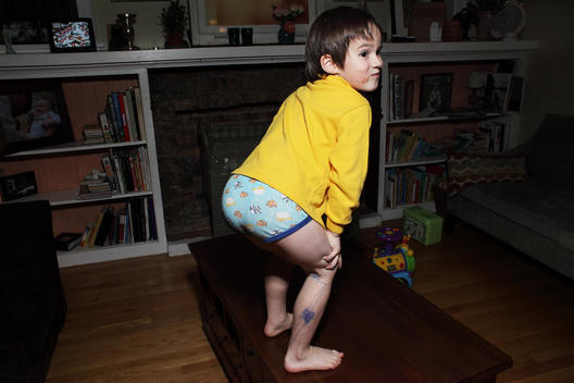 Little boy sticking his bum out in blue under pants and yellow top
