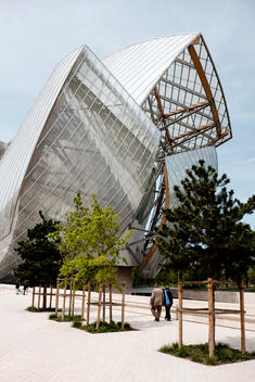 An elderly couple walks along the Frank Gehry-designed Fondation Louis Vuitton museum in Paris, France.