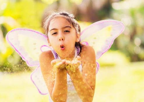 girl (8-9) blowing fairy dust