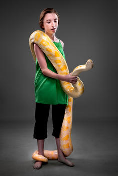Teenage girl holding ten foot yellow and white python, full body
