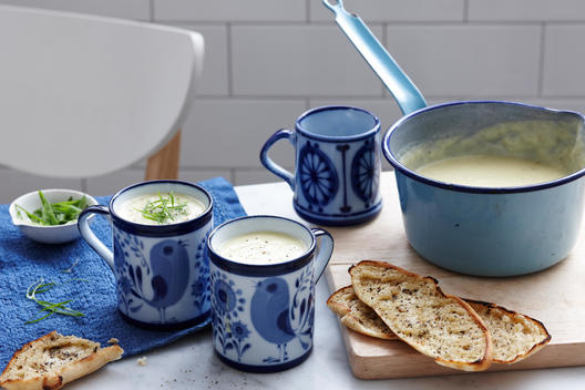 Meal with mugs of leek and potato soup with bread