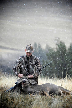 Deer hunter holding up dead stags antlers, John Day, Oregon, USA