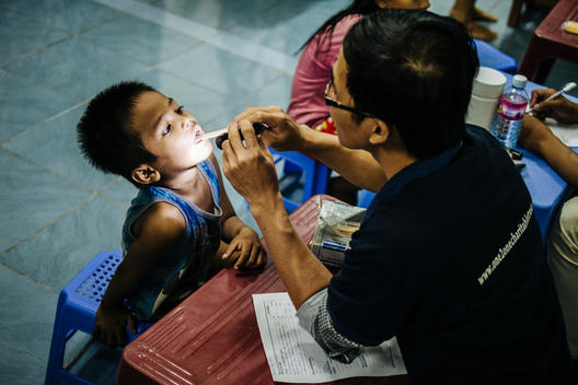 A doctor checks out a baby at Empowering Youth in Cambodia\'s Aziza School in Phnom Penh, Cambodia. One 2 One provides free medical services to the commnity weekly at the school.
