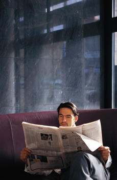 Businessman sitting and reading newspaper