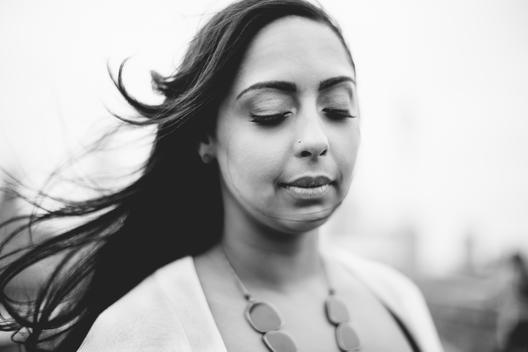Close up portrait of mixed race black woman tranquil, clam and closing eyes in Dumbo, Brooklyn, NYC