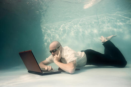 business man with a laptop underwater