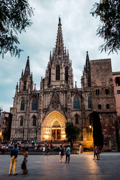 People walk through the square in front of the Cathedral of the Holy Cross and Saint Eulalia, better known as Barcelona Cathedral in Barcelona, Spain.