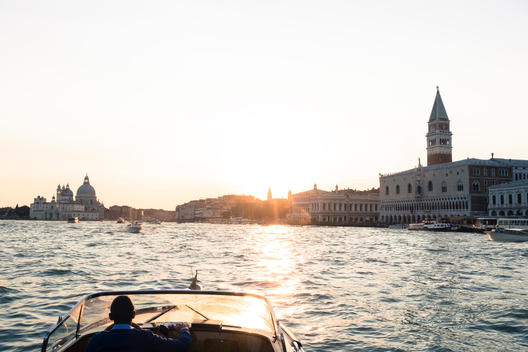 Late day sun falls upon a water taxi with views along the Grand Canal.