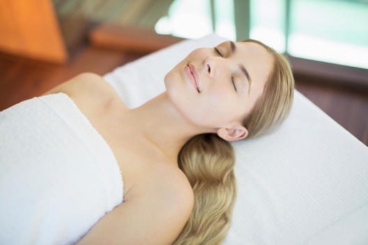 Smiling woman relaxing on massage table in spa