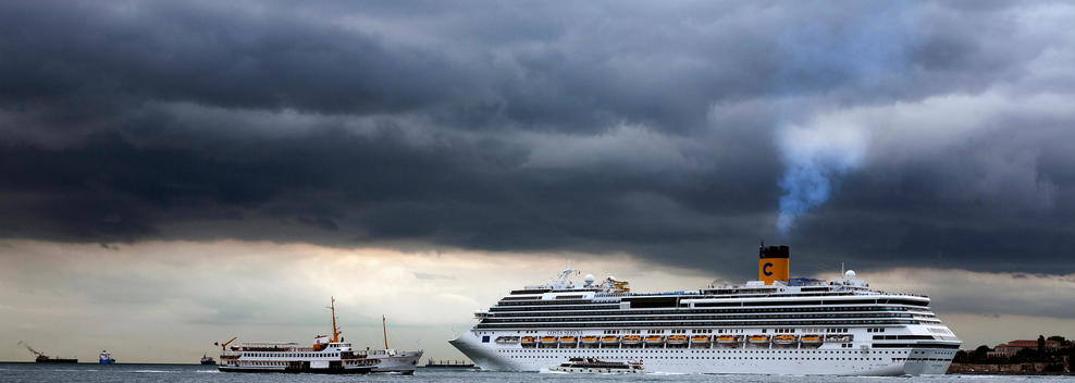 The Passenger Cruise Liner Passing The Bosphorus Leaving A Heavy Smoke From Its Chimney In Istanbul Turkey