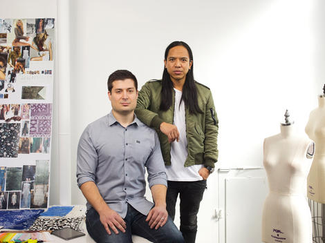 The two founders of the clothing company Revolve stand by dress forms and an idea board in the company\'s headquarters