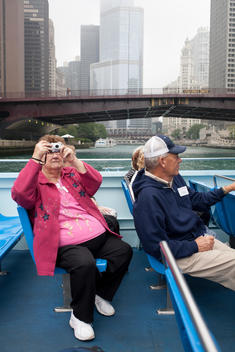 An Elderly Woman Take Pictures While On A Boat Tour On The Chicago River.