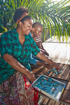 African American woman solving puzzle with family on patio