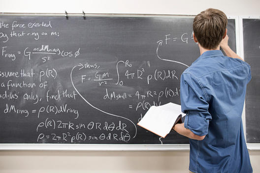 Caucasian student writing on blackboard