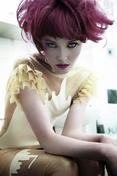 Pale skin model with red hair looking in the lens with piercing blue eyes