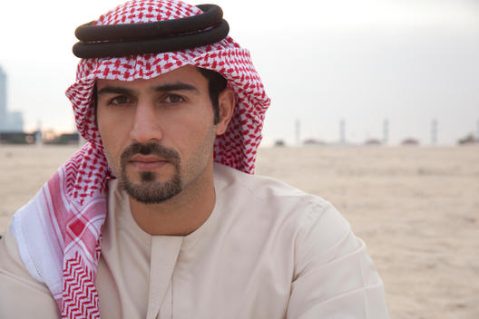 Portrait of an Arabic man wearing a Saudi style ghoutra, on a beach.