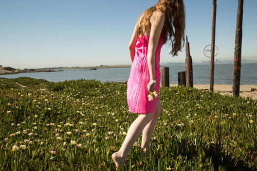 Young woman in pink slip dress on Northern CA beach.