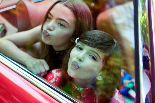 Two girls in red car