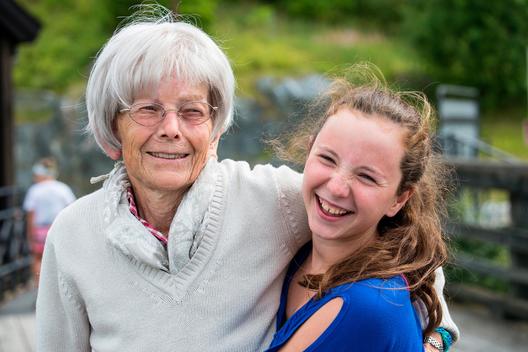 Portrait of grandmother and granddaughter (13-15) holding each other, smiling