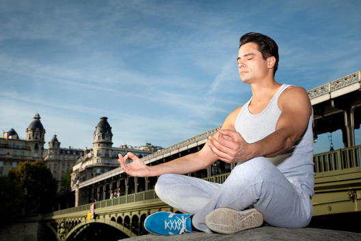 Athletic man performing yoga in urban setting, Lotus Pose