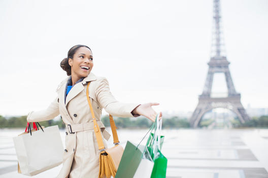 Woman carrying shopping bags by Eiffel Tower, Paris, France