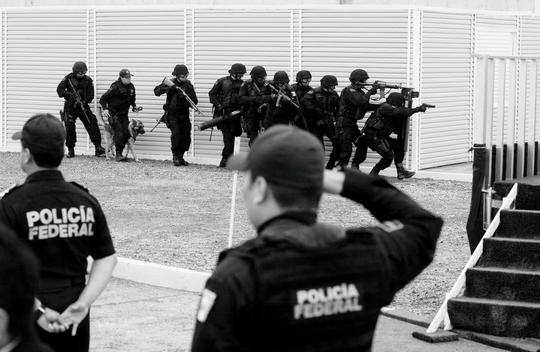 Mexico City, Mexico June 16, 2008 Secretary of Public Security Genaro Garcia Luna, Mexico\'s President Felipe Calderon and Interior Minister Juan Camilo Mourino watch as a SWAT teams demonstrate their maneuvers during the opening of a new federal police ce
