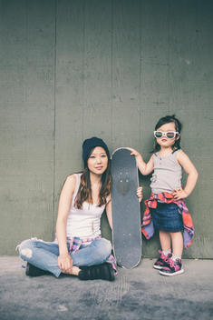 Korean mother and daughter posing with skateboard