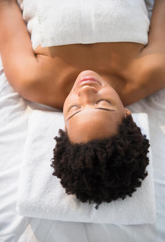 Serene Black woman laying on massage table