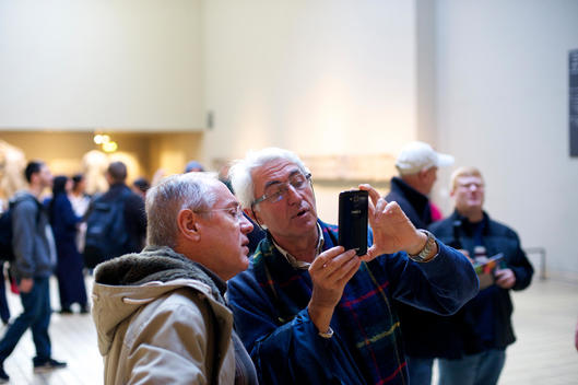 Two Caucasian males looking at a Smartphone in the British Museum in London
