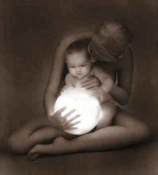 Anonymous seated nude woman holding anonymous baby, both touching large luminous lit globe