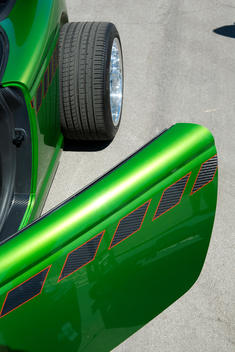The side of a green Foose car showing the back tire and driver\'s side door open