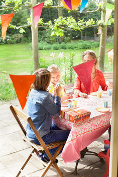 Mother chatting with children at patio table
