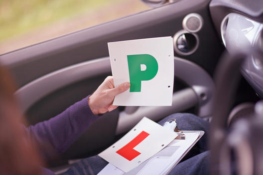 Driving instructor awarding learner driver with Passed Plate