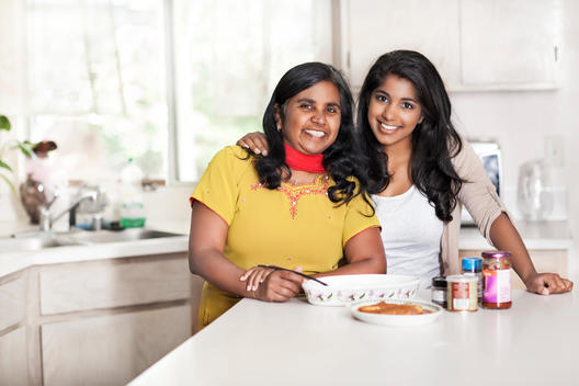 Indian mother and daughter cooking in kitchen
