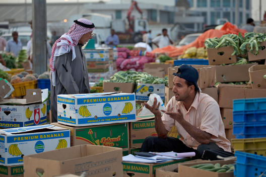 A Vendor At The Fruit And Vegetable Market In Al Mina, Abu Dhabi, United Arab Emirates.