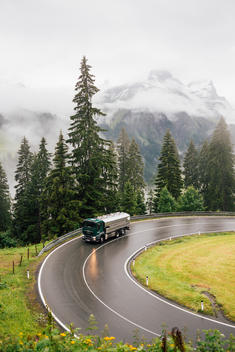 truck driving through turn in alpine landscape in Austria during bad weather.