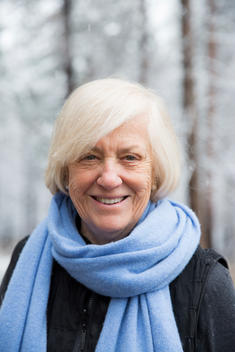 portrait of older woman in snow with blue scarf