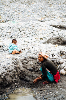 A Nepalese woman works with her daughter nearby at the sand mines in Pokhara, Nepal.